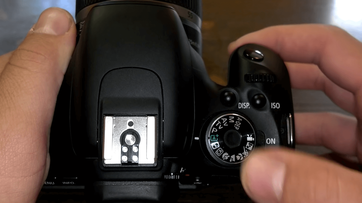 Rotate the dial of Canon camera and enable "no flash" mode
